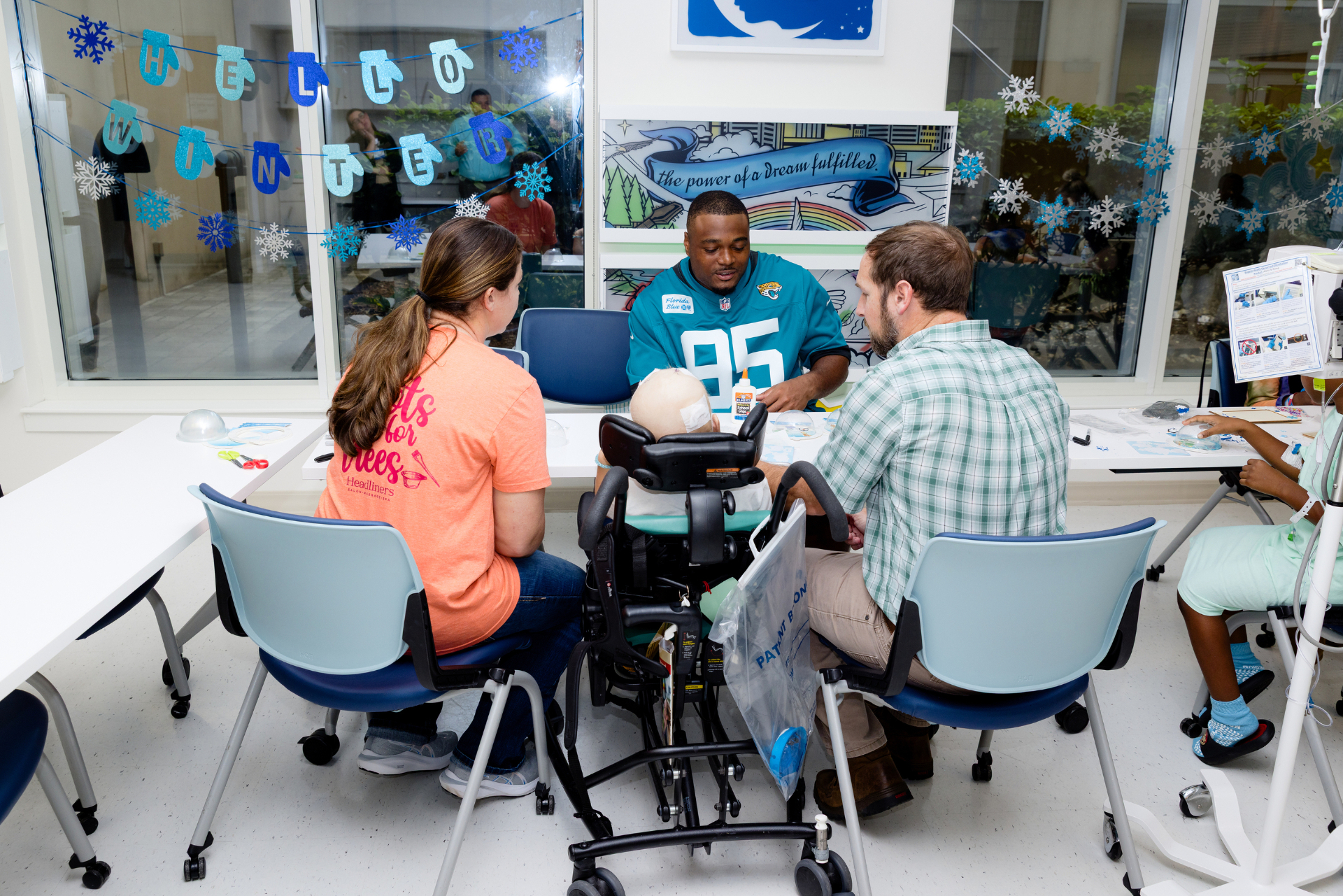 BJ Green doing a craft activity with a child patient and family in the hospital